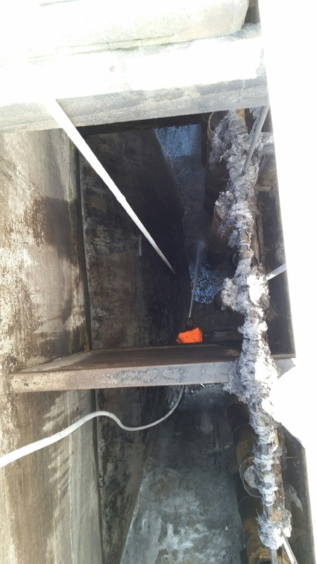 Sludge and debris removal in an empty water tank after industrial dewatering services by Bullock Construction.