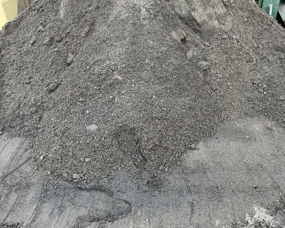 Close-up of dewatered sludge cake — the solid byproduct left after water is removed from dredged sediment using a dewatering system.