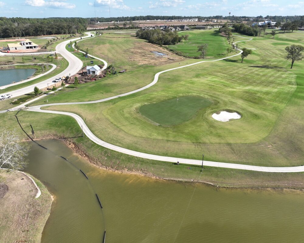 An aerial drone image showcasing a hydraulic dredging project at a golf course to restore water flow and keeping the water feature clean and pristine.